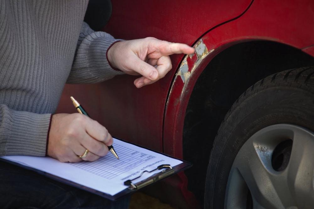 Chicago lawyer reviewing car accident damage assessment and repair costs with client.