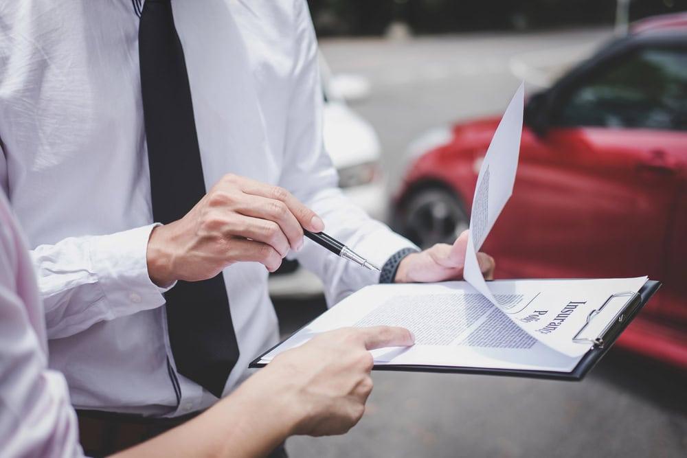 Attorney negotiating with an insurance adjuster over a denied auto insurance claim.