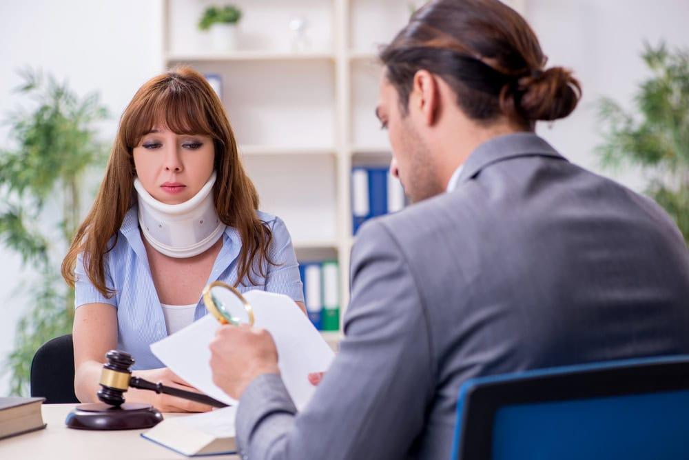 Woman reviewing paperwork to file a whiplash claim after a rear-end collision